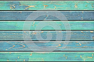 Texture of old wooden fence in turquoise green shades, hues. Rustic natural wooden planks, cracks, scratches for