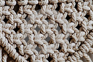 Texture of open-weaved macrame tapestry up close. Knots and ropes in a pattern