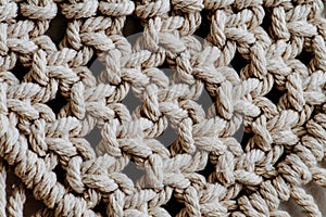 Texture of open-weaved macrame tapestry up close. Knots and ropes in a pattern photo