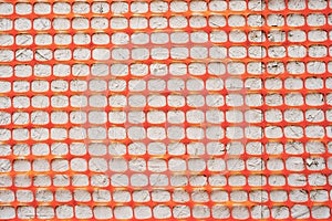 Texture Orange fence construction mesh close-up on a gray background.