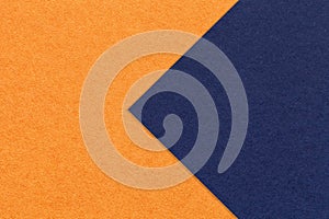 Texture of orange and navy blue paper background, half two colors with arrow, macro. Structure of dense craft cardboard