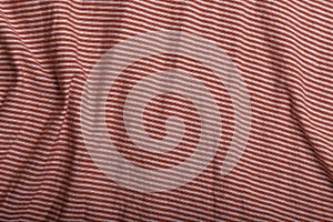 Texture of orange and white striped cotton wrinkled fabric, background or backdrop. Clothing, sewing, gressmaking, haberdashery.