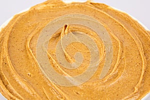 Texture of peanut butter. Whirlwind propagation. Organic keto food. Healthy creamy paste. Smooth brown desert close up
