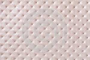 Texture of pearl beige leather background with capitone pattern, macro