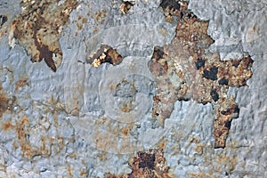 Texture of peeling paint on rusty metal. The steel surface is gray color affected by corrosion. Background with rust on the wall