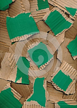 Texture from pieces of torn colored cardboard. Green brown carton background. Recycling concept. Rough pieces of ripped corrugated