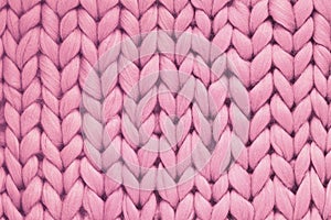 Texture of pink wool big knit blanket. Large knitting. Plaid merino wool. Top view