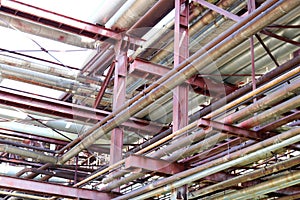 The texture of a pipeline overpass with iron rusty pipes for pumping liquids with outlets and drains at an oil refinery, petrochem