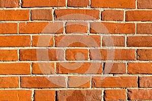 The texture of red antique brick. Background of old red brick wall texture with deterioration from age. The brick wall is lit by