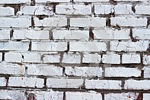 The texture of red brick painted with white cracked paint. Old wall.