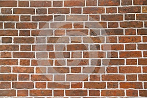 Texture of a red brick wall laid with white cement