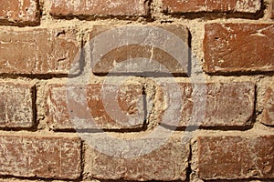 Texture of a red brick wall with sand