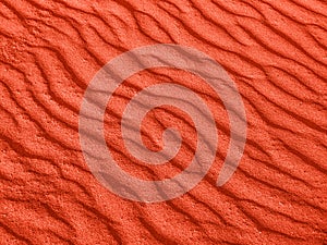 Texture of red sand waves on the beach or in the desert. the ripples of the sand is diagonal.