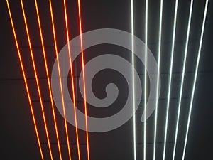 Texture of red and white glowing bright neon LED multicolored laser abstract stripes and lines from parallel lamps. The background