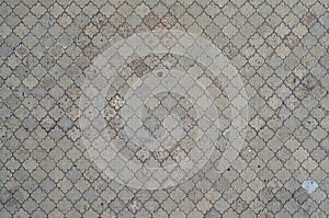 The texture of a rhythmic mosaic made of concrete tiles. Background image of a large area of old and damaged gray tile