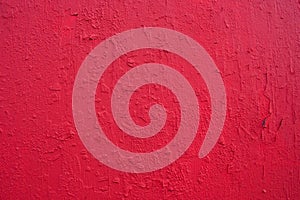 Texture of rough concrete wall covered and painted red decorative stucco.Background of blood-red colored plaster with cracks