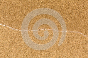 Texture sand beach with soft waves. Sea.