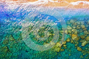 Texture of sea with clear turquoise water and bottom top view with the drone. iridescent yellow blue colors