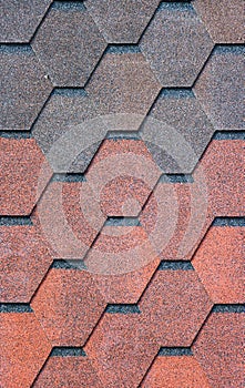 The texture of the shingles is close-up. Roofing material