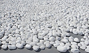 Texture of small, white beach stones on grey