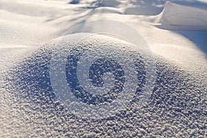 Texture of the snow mound. At sunlight snowflakes glisten