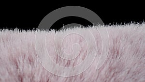 Texture of soft fluffy pink fur fabric on black background. Faux hairy fur. Fluffy fake fur clothes, furry blanket. The