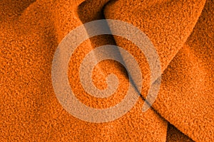 The texture of a soft warm orange fabric. Closeup