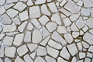 The texture of the stone road, pavement, walls of large gray old medieval round strong stones, cobblestones. The background