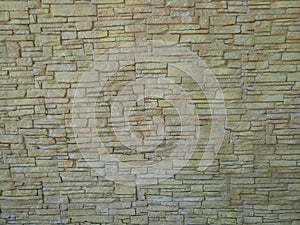 Texture stone wall made of small yellow bricks