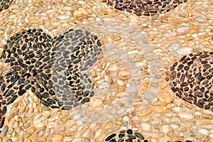 Texture stone wall road from small round oval stones abstract lines laid out patterns natural old yellow black brown background