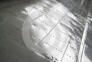 The texture of the surface of the aluminum wing of the aircraft with rivets.