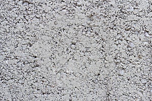 The texture of the surface of the gray cinder block.