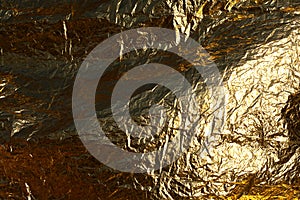 Texture of a thin crumpled sheet of foil. Crumpled foil background. Stock photo foil. Gold chrome color
