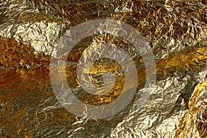 Texture of a thin crumpled sheet of foil. Crumpled foil background. Stock photo foil. Gold chrome color