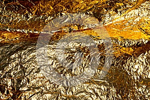 Texture of a thin crumpled sheet of foil. Crumpled foil background. Stock photo foil. Gold chrome color