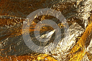 Texture of a thin crumpled sheet of foil. Crumpled foil background. Stock photo foil. Gold chrome color