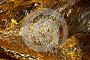 Texture of a thin crumpled sheet of foil. Crumpled foil background. Stock photo foil. Gold chrome color