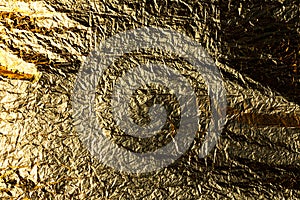 Texture of a thin crumpled sheet of foil. Crumpled foil background. Stock photo foil. Gold chrome color