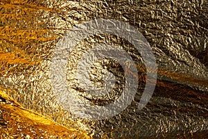 Texture of a thin crumpled sheet of foil. Crumpled foil background. Stock photo foil. Gold chrome color