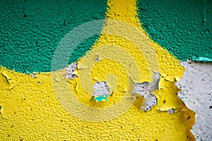 Texture of a two-color yellow and green old shabby concrete wall with bulbous peeling varicoloured paint, pits and patterns