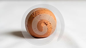 Texture is uneven with visible cracks and indentations giving it a