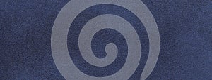 Texture of velvet matte navy blue background, macro. Suede denim fabric with pattern. Seamless textile felt backdrop