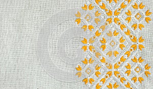 Texture of the vintage homespun linen textile with embroidery. Design of ethnic pattern. Craft embroidery.