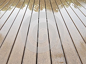 Texture of vintage lath wood plank panel floor wet from rain with reflection of tree