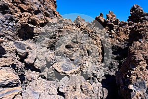 The texture of the volcanic surface. Pumice stone and frozen lava against a blue sky