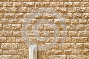 Texture of the wall built of rough yellow stone blocks