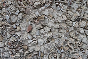 Texture of wall with light gray gravel pebble dash