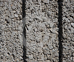 Texture of a wall of small, small gray stones with two dimples in the middle