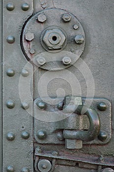 The texture of the wall of the tank, made of metal and reinforced with a multitude of bolts and rivets. Images of the covering of