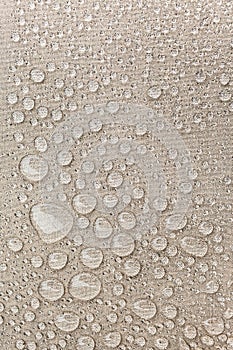 Texture of water drops on fabric textile close-up. Rain background